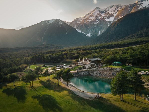 Luftbild der Stöttlalm mit dem türkisen Naturbadesee vor der Mieminger Kette.